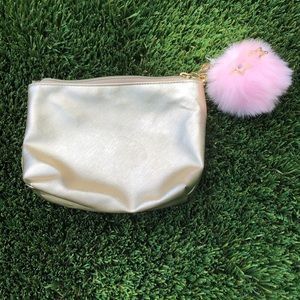 Golden makeup bag with pink fluffy attachment